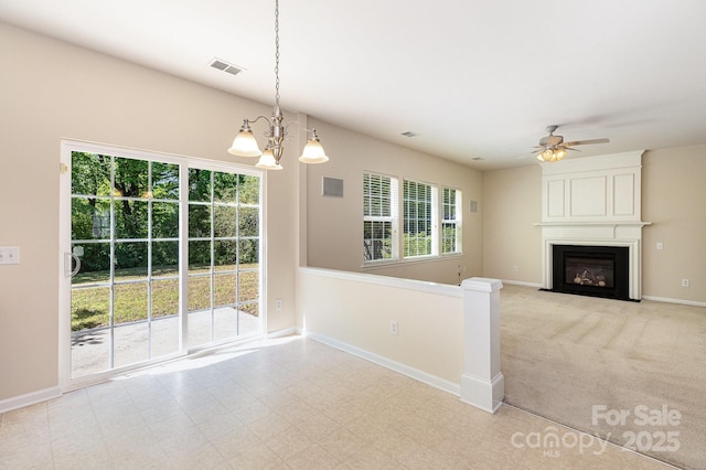 unfurnished living room featuring a fireplace, baseboards, visible vents, and ceiling fan with notable chandelier