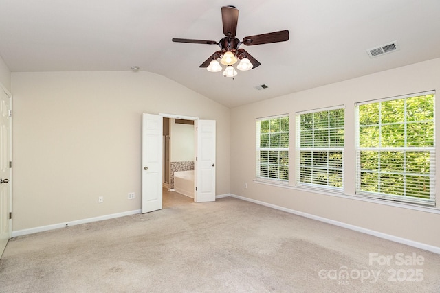 unfurnished bedroom featuring lofted ceiling, baseboards, visible vents, and light colored carpet
