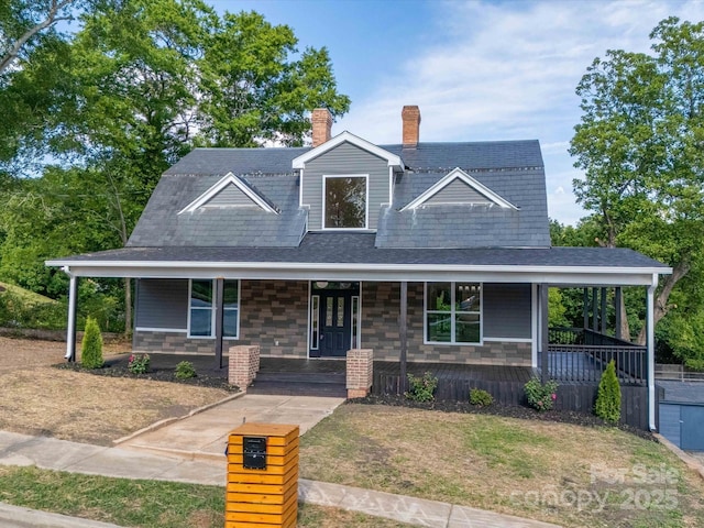 view of front facade with covered porch, a front lawn, and roof with shingles