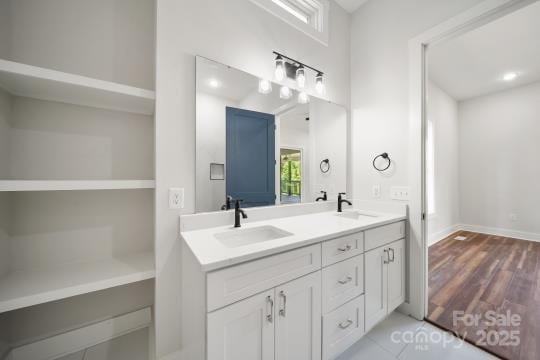 bathroom featuring double vanity and baseboards