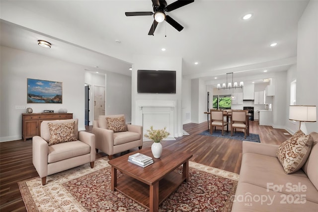 living room featuring ceiling fan, wood finished floors, baseboards, a chandelier, and recessed lighting