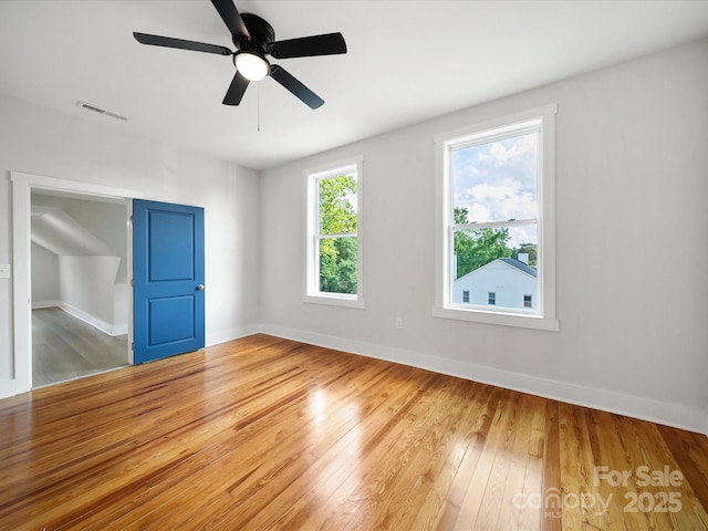 empty room with wood-type flooring, baseboards, and a ceiling fan