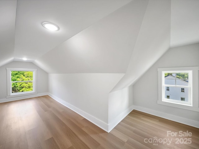 bonus room with lofted ceiling, wood finished floors, and baseboards
