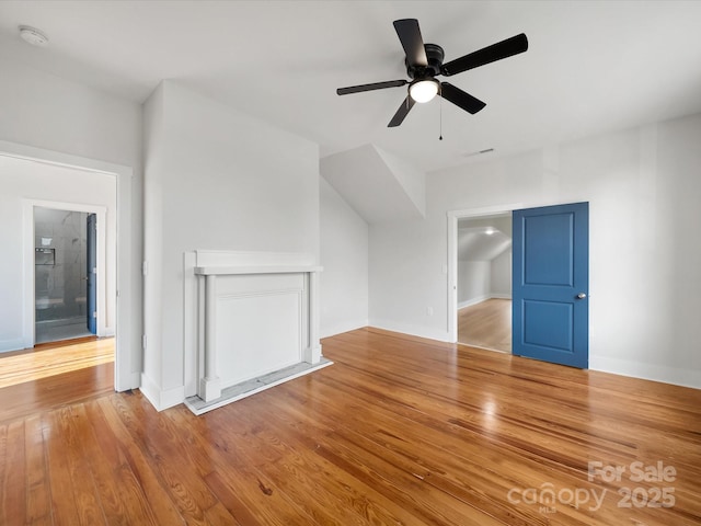 additional living space with a ceiling fan, wood finished floors, and baseboards