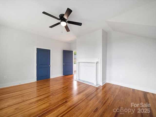 unfurnished living room with a ceiling fan, wood finished floors, and baseboards