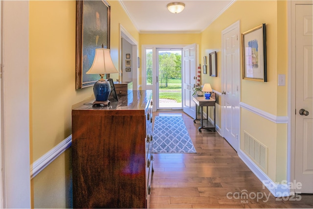 doorway to outside with crown molding, wood finished floors, and an office area