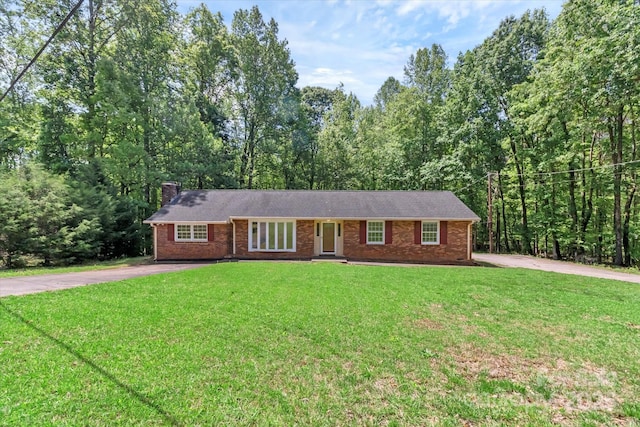 182 Freedom Mill Rd, Gastonia, NC 28052 - ranch-style house featuring a front yard, brick siding, a view of trees, a chimney, and concrete driveway