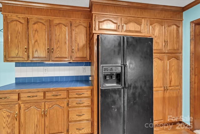 182 Freedom Mill Rd, Gastonia, NC 28052 - kitchen featuring tile counters, black refrigerator with ice dispenser, brown cabinets, and decorative backsplash