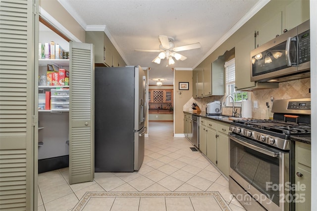 106 S Oakwood Dr, Kings Mountain, NC 28086 - kitchen with dark countertops, light tile patterned floors, a sink, decorative backsplash, and appliances with stainless steel finishes