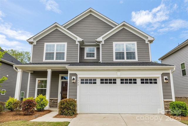 1933 Tin Roof Ln, Monroe, NC 28112 - view of front of home with driveway, a porch, an attached garage, and stone siding