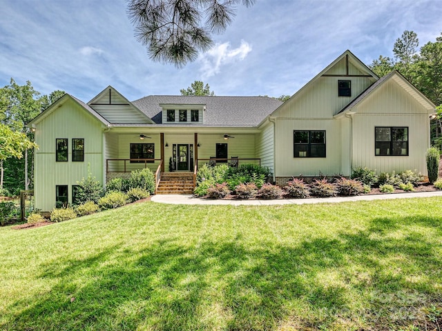 view of front of home featuring a porch, a ceiling fan, a shingled roof, and a front yard