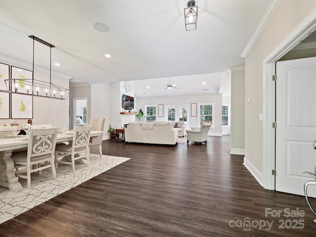 living room with baseboards, dark wood-style flooring, crown molding, and recessed lighting