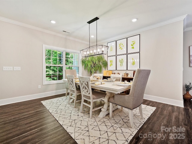 dining space with baseboards, wood finished floors, and ornamental molding