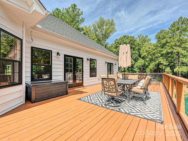 wooden terrace featuring outdoor dining area and french doors