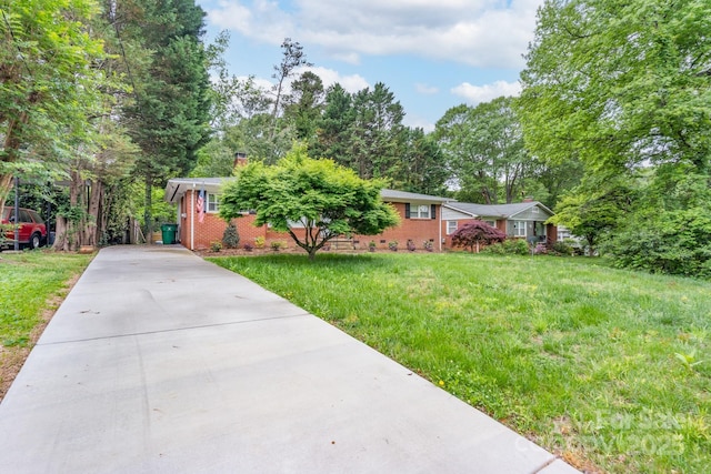 4920 Raymond Pl, Charlotte, NC 28205 - ranch-style house with concrete driveway, a chimney, a front yard, and brick siding