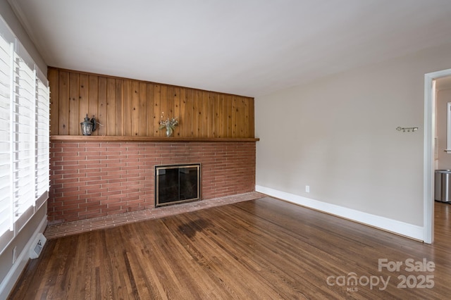 4920 Raymond Pl, Charlotte, NC 28205 - unfurnished living room with dark wood-style floors, a fireplace, baseboards, and wooden walls