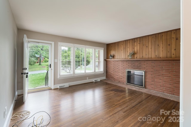 4920 Raymond Pl, Charlotte, NC 28205 - unfurnished living room with wood finished floors, healthy amount of natural light, baseboards, and wood walls