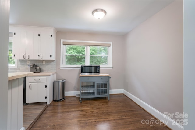 4920 Raymond Pl, Charlotte, NC 28205 - kitchen featuring stainless steel microwave, light countertops, dark wood finished floors, baseboards, and white cabinets