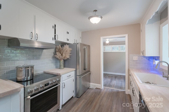 4920 Raymond Pl, Charlotte, NC 28205 - kitchen with under cabinet range hood, stainless steel appliances, a sink, dark wood finished floors, and light countertops