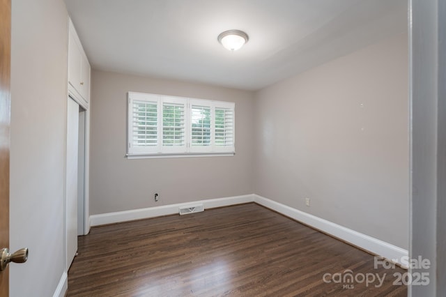 4920 Raymond Pl, Charlotte, NC 28205 - unfurnished bedroom featuring dark wood-style floors, baseboards, and a closet