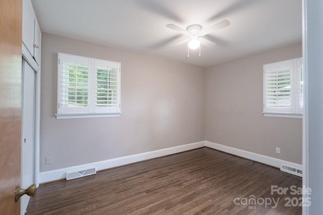 4920 Raymond Pl, Charlotte, NC 28205 - unfurnished bedroom featuring multiple windows, dark wood-style flooring, baseboards, and a closet