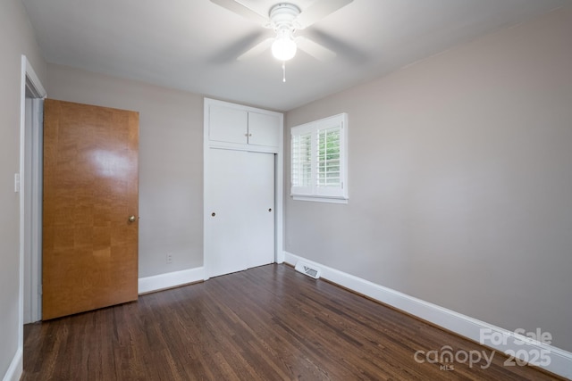 4920 Raymond Pl, Charlotte, NC 28205 - unfurnished bedroom with baseboards, dark wood-style flooring, a closet, and a ceiling fan