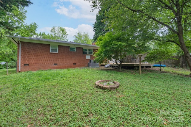 4920 Raymond Pl, Charlotte, NC 28205 - rear view of house featuring crawl space, brick siding, central AC, a wooden deck, and a fire pit