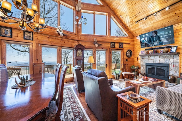 living room featuring hardwood / wood-style floors, a chandelier, wooden walls, wooden ceiling, and rail lighting