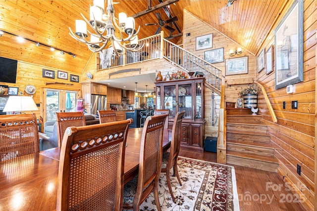 dining room with high vaulted ceiling, wood walls, wood ceiling, and a notable chandelier