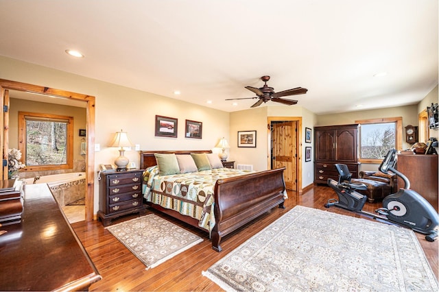 bedroom with wood finished floors, recessed lighting, and multiple windows