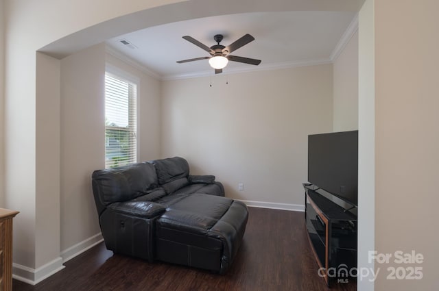 living room with dark wood-type flooring, crown molding, and baseboards