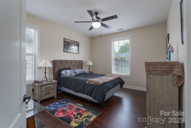 bedroom featuring baseboards, a ceiling fan, visible vents, and dark wood finished floors