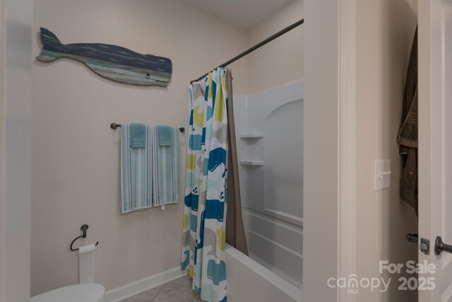 bathroom featuring shower / bath combo, baseboards, tile patterned flooring, and toilet