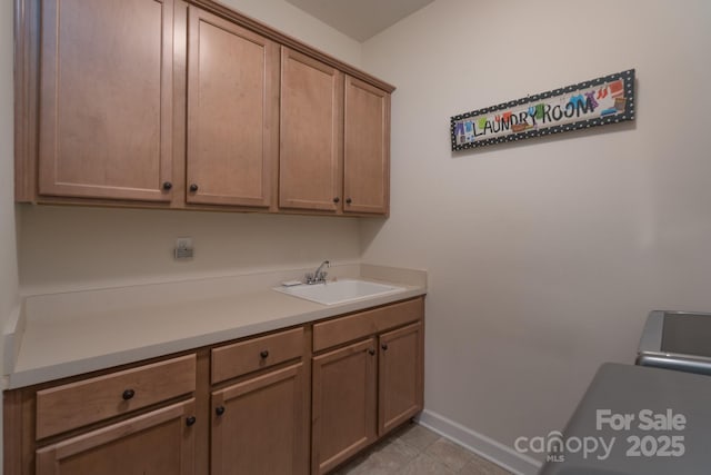 washroom with baseboards and a sink
