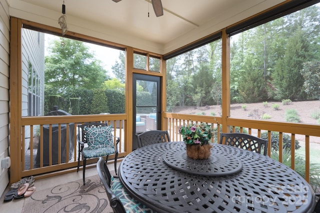 sunroom featuring a wealth of natural light, outdoor dining area, and ceiling fan