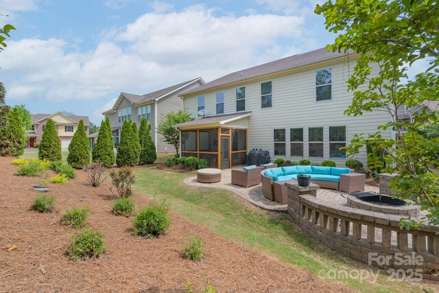 rear view of house featuring a yard, a sunroom, an outdoor living space, and a patio area