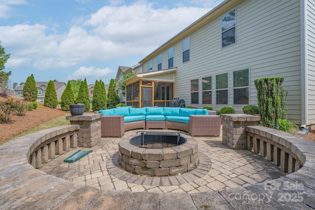 view of patio / terrace with an outdoor fire pit and a sunroom