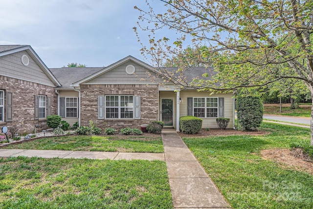 single story home featuring a front yard and brick siding