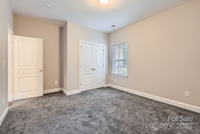 unfurnished bedroom with carpet, visible vents, and baseboards