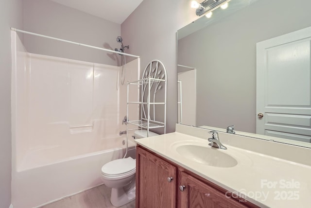 bathroom with wood finished floors, toilet, bathtub / shower combination, and vanity