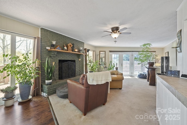 3190 Holly Rd, Connelly Springs, NC 28612 - living area with a textured ceiling, ceiling fan, a fireplace, french doors, and light wood finished floors