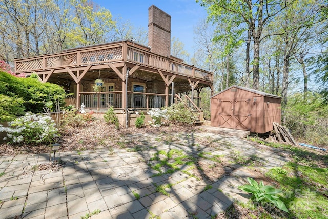 3190 Holly Rd, Connelly Springs, NC 28612 - rear view of house featuring a chimney, a shed, a deck, a patio, and brick siding