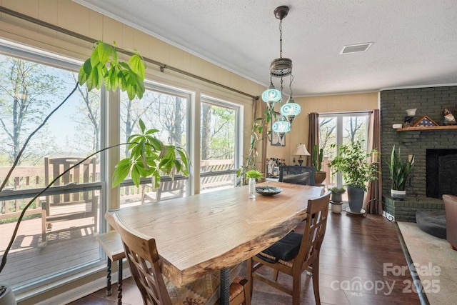 3190 Holly Rd, Connelly Springs, NC 28612 - dining space with ornamental molding, wood finished floors, a textured ceiling, and a brick fireplace