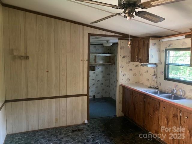 314 Phillips Dr, Forest City, NC 28043 - kitchen with a sink, ceiling fan, vaulted ceiling, water heater, and wooden walls