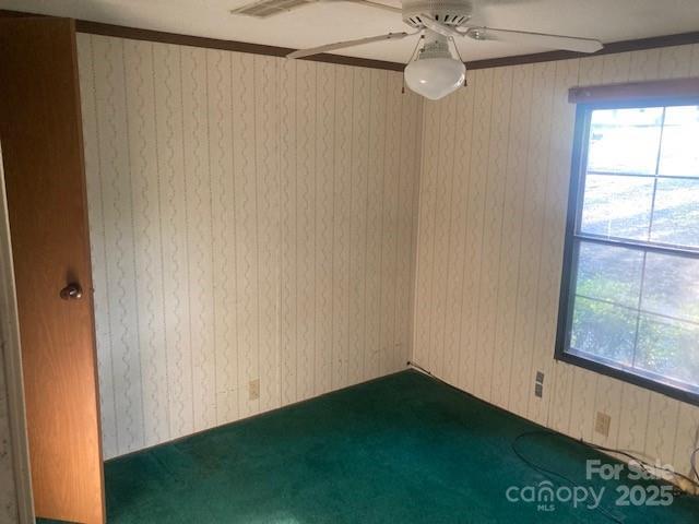 314 Phillips Dr, Forest City, NC 28043 - unfurnished room featuring dark carpet, a ceiling fan, and wooden walls