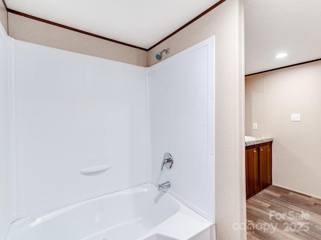 full bathroom featuring washtub / shower combination, wood finished floors, vanity, and crown molding