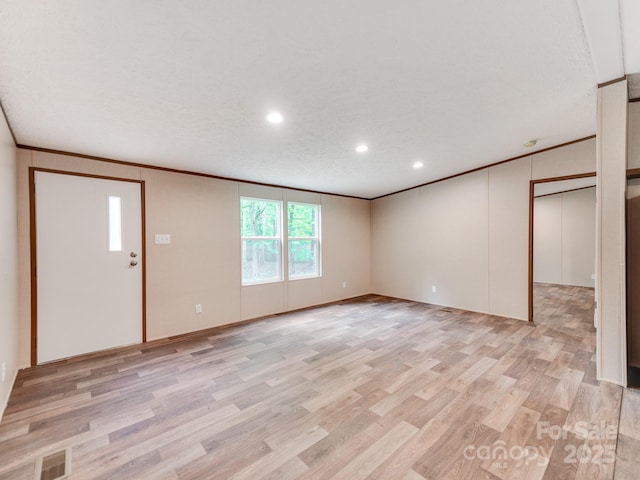 unfurnished living room featuring light wood-style flooring, baseboards, recessed lighting, and ornamental molding