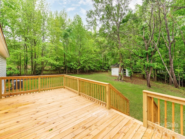 wooden terrace featuring an outdoor structure, a storage unit, central air condition unit, and a lawn