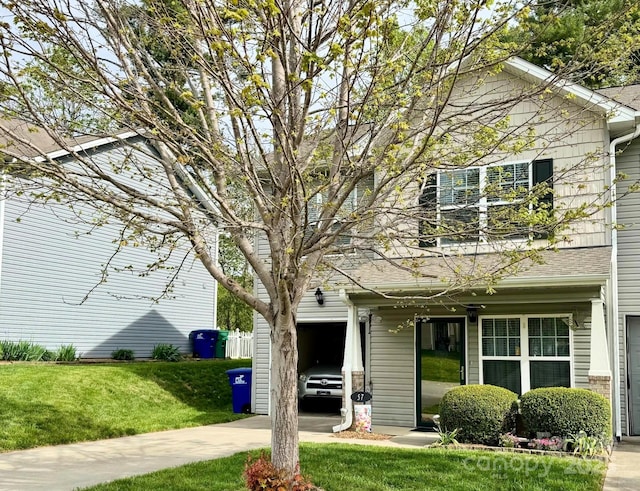 view of front facade with concrete driveway and a front lawn