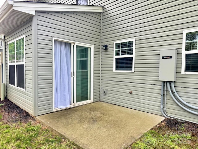 view of exterior entry featuring a patio area